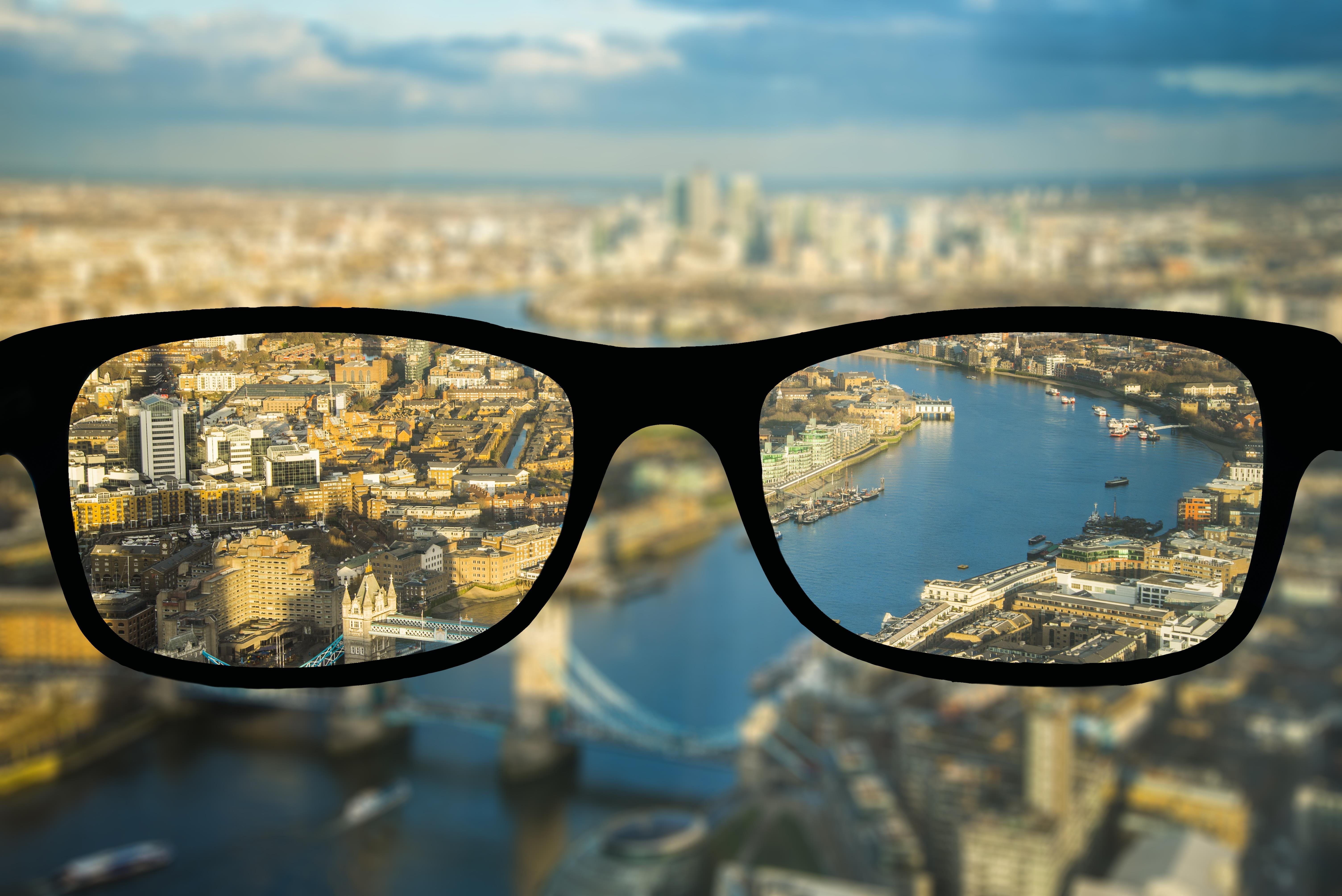 Immobilien Global Schwarze Brille und im Hintergrund ist eine Stadt zu sehen